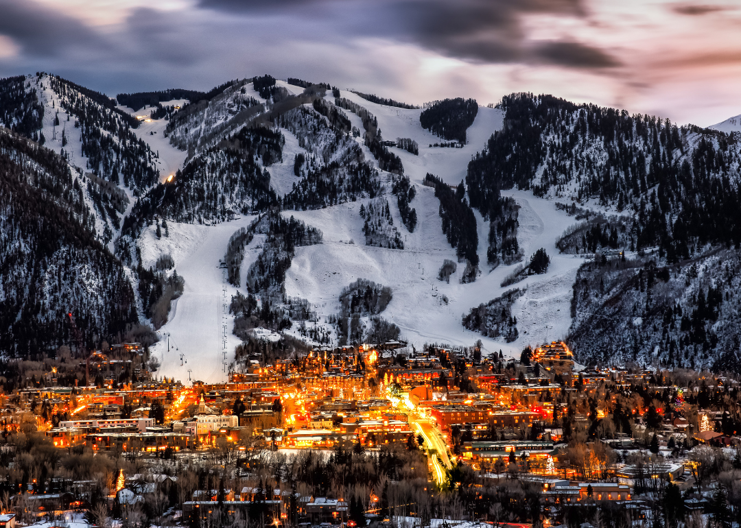 Aerial view of Aspen at night with huge mountains in the background. 