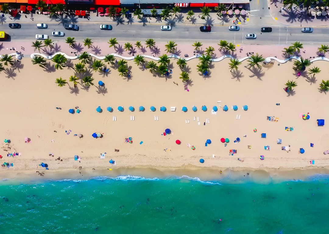 Drone view of umbrellas on the beach and street in Fort Lauderdale.