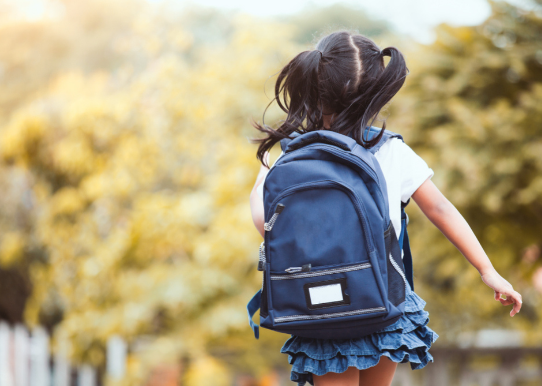 A girl running with a backpack.