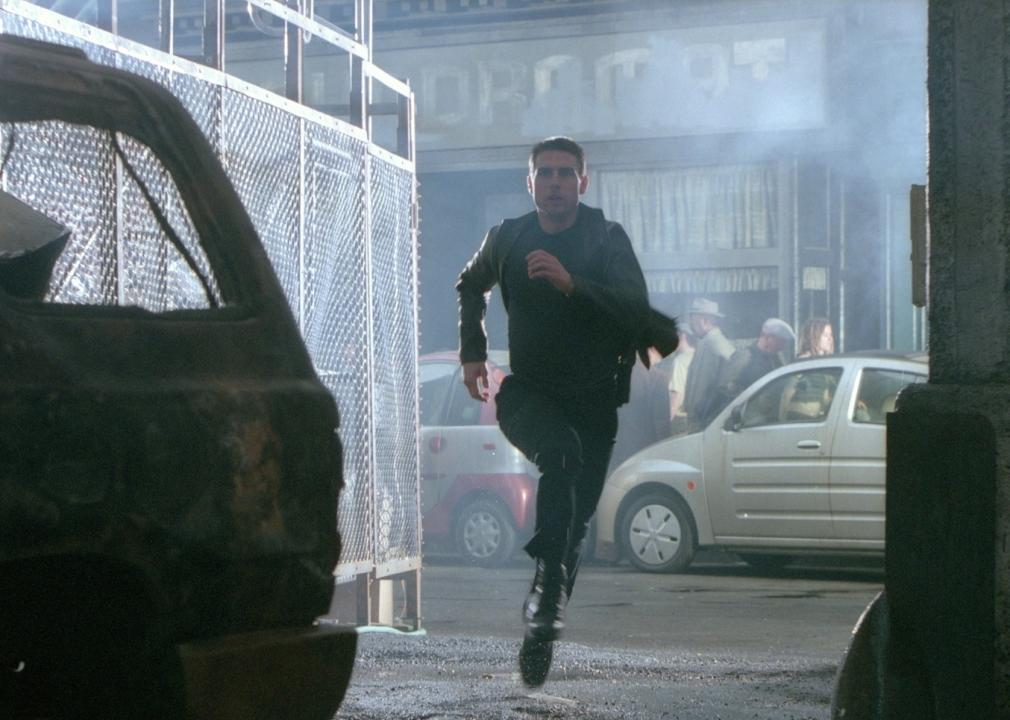 Man dressed in all black running down an alley.