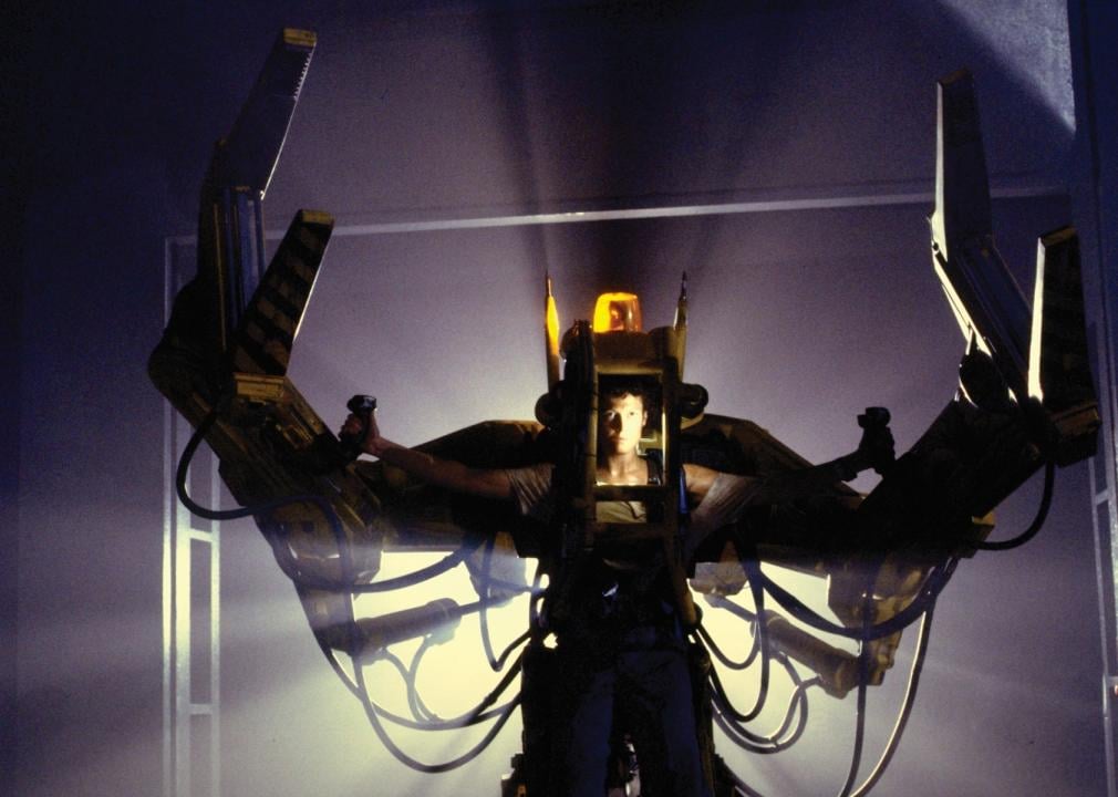 A woman in a giant robotic suit with metal arms on the sides and lights on top.