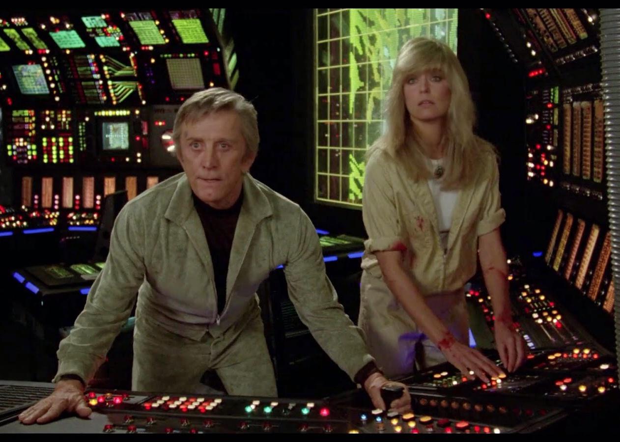 Kirk Douglas and Farrah Fawcett in the control room of a ship.