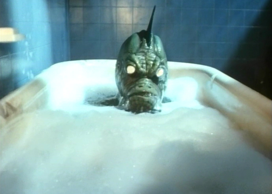 A green creature sitting in a bubble bath.