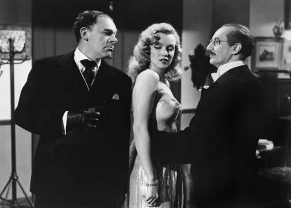 Groucho Marx, Marilyn Monroe, and Otto Waldis in a scene from 