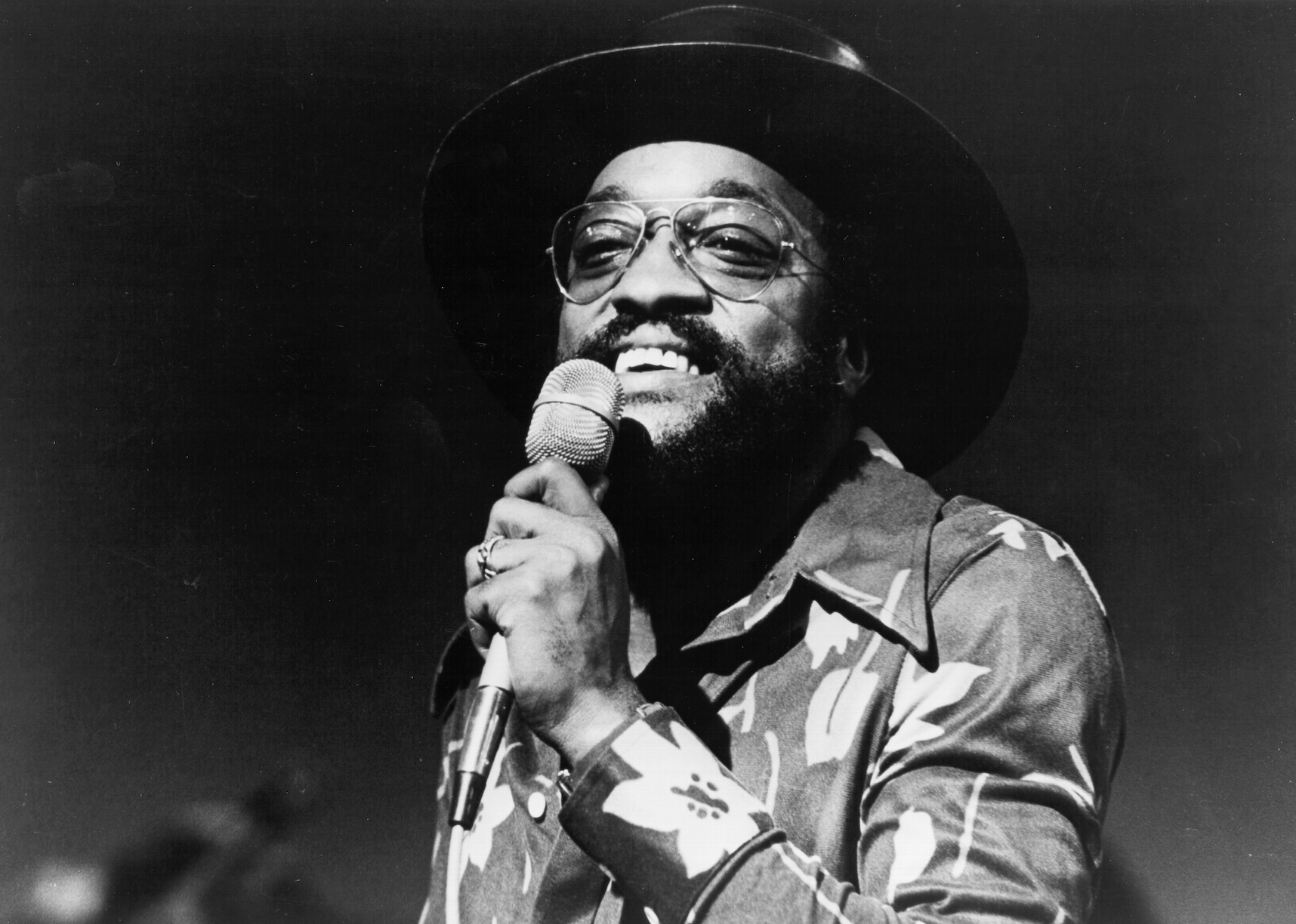 Photo of Billy Paul with microphone smiling.