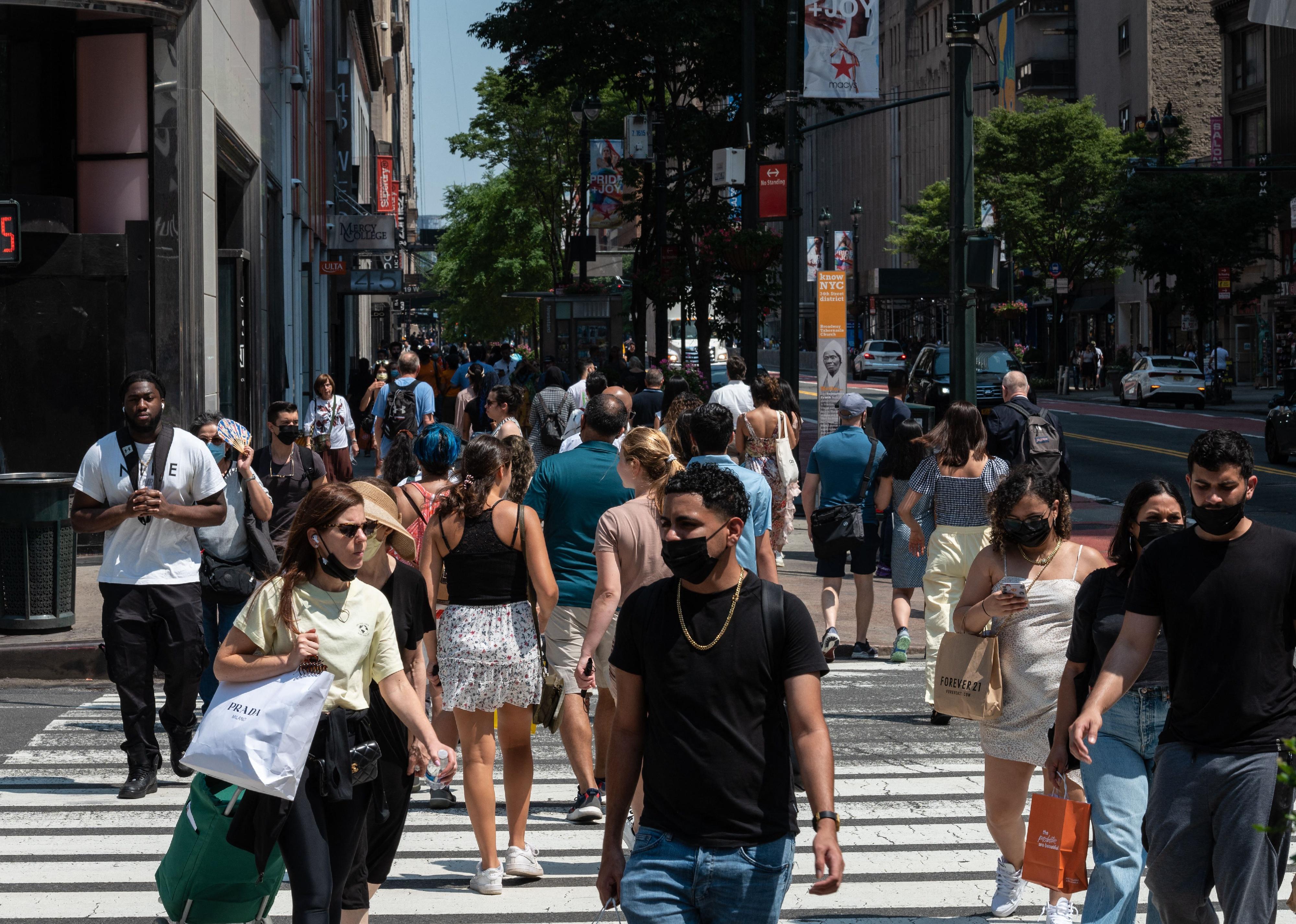 Shoppers walking down a busy New York street.