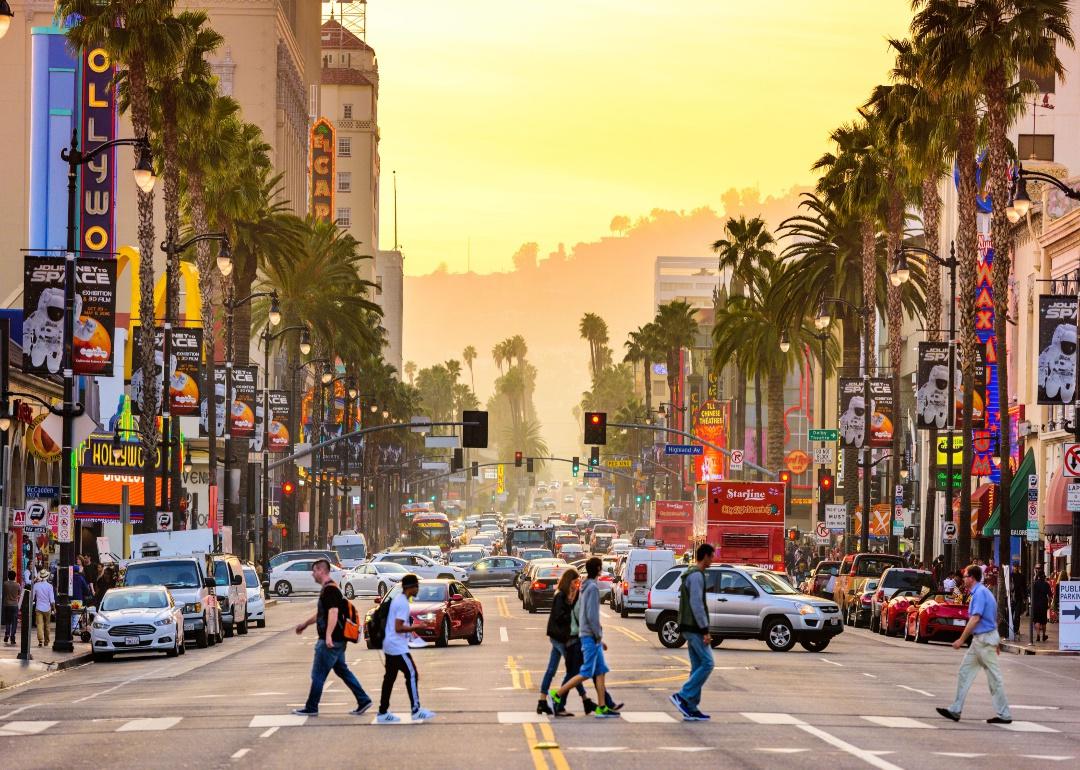 Hollywood streets at sunset lined with palm trees and crowded with people. 