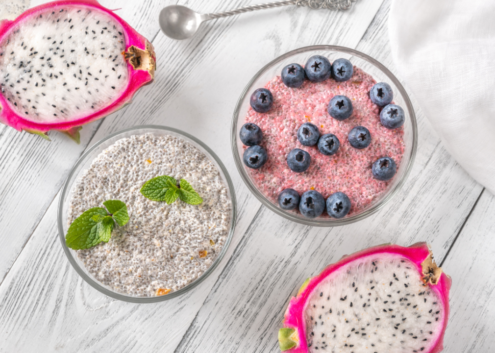 Bowls of chia pudding with mint leaves and blueberries on top.