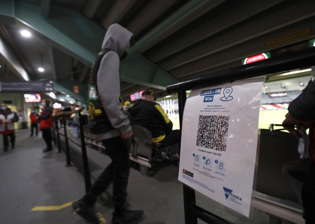 A fan walking past a QR code sign in a seating area.