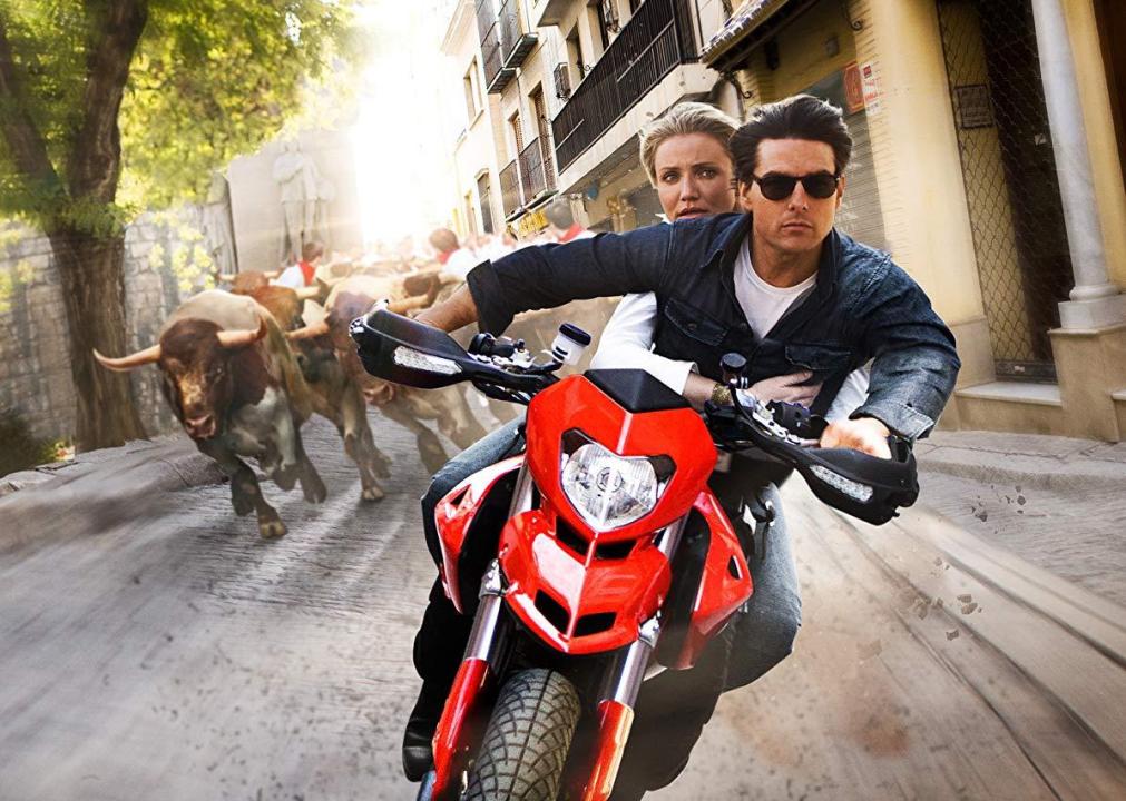 Tom Cruise and Cameron Diaz on a motorcycle running from charging bulls.