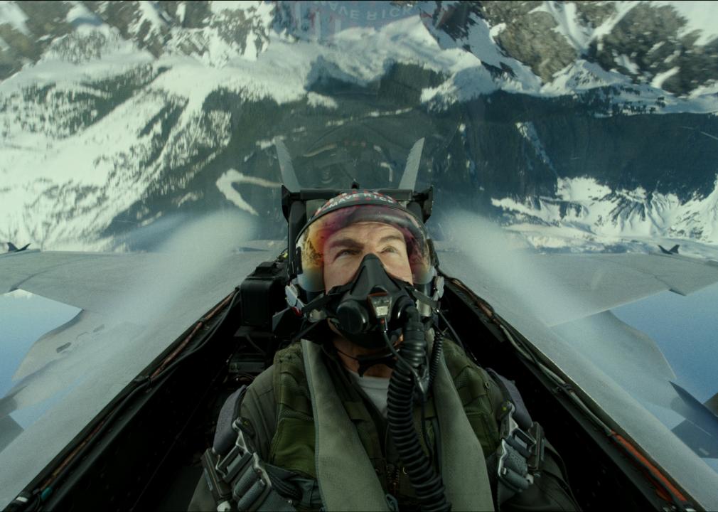 Tom Cruise in a fighter jet going over snow-capped mountains.