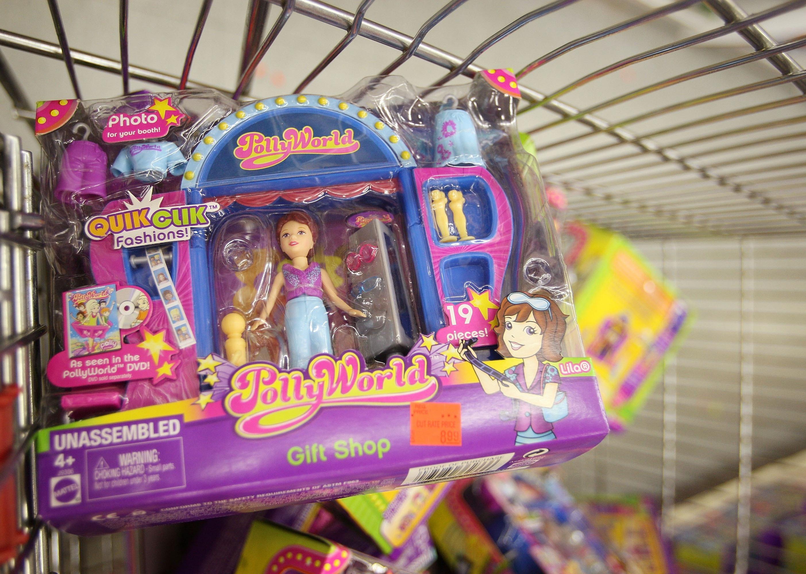 A colorful Polly Pocket playset sits in a basket full of recalled toys at a toy store.