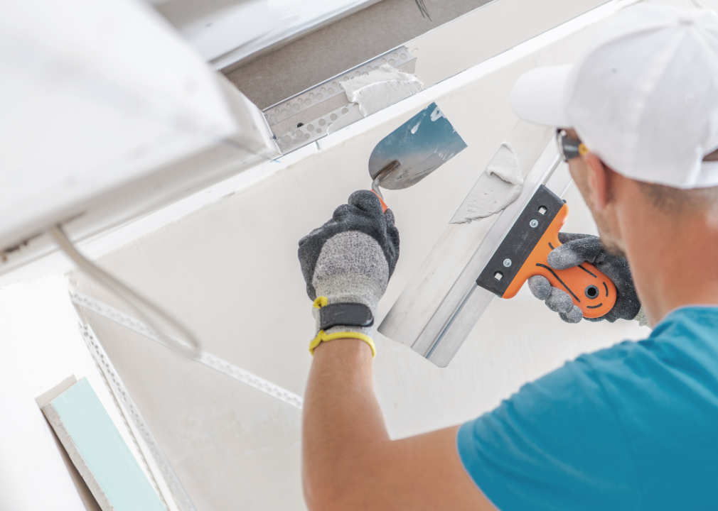 A man building a drywall ceiling.