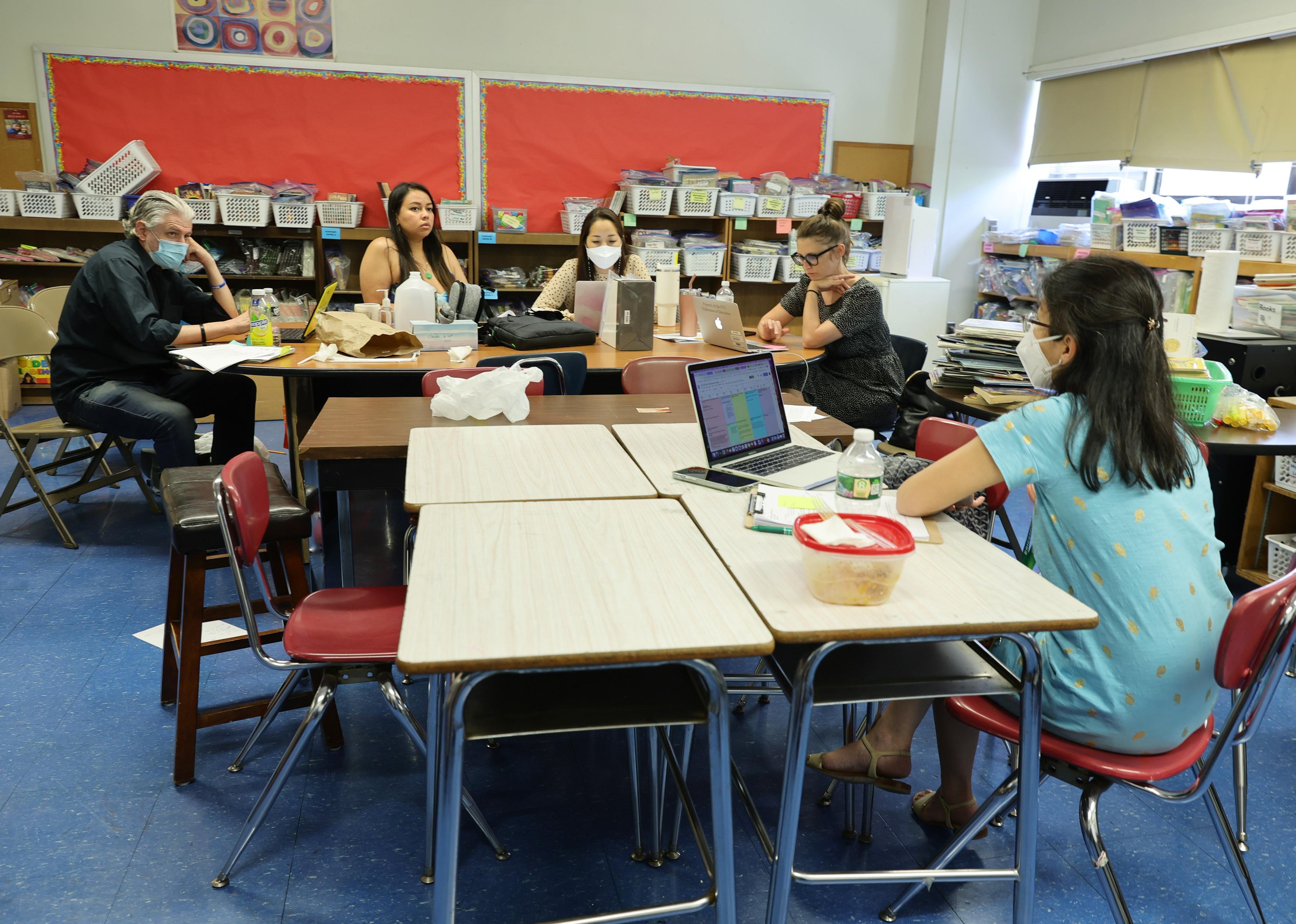 Students at tables with computers in a classroom.