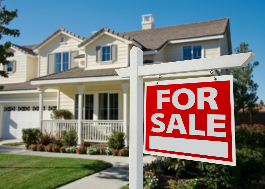 "For Sale" sign in front of a house.
