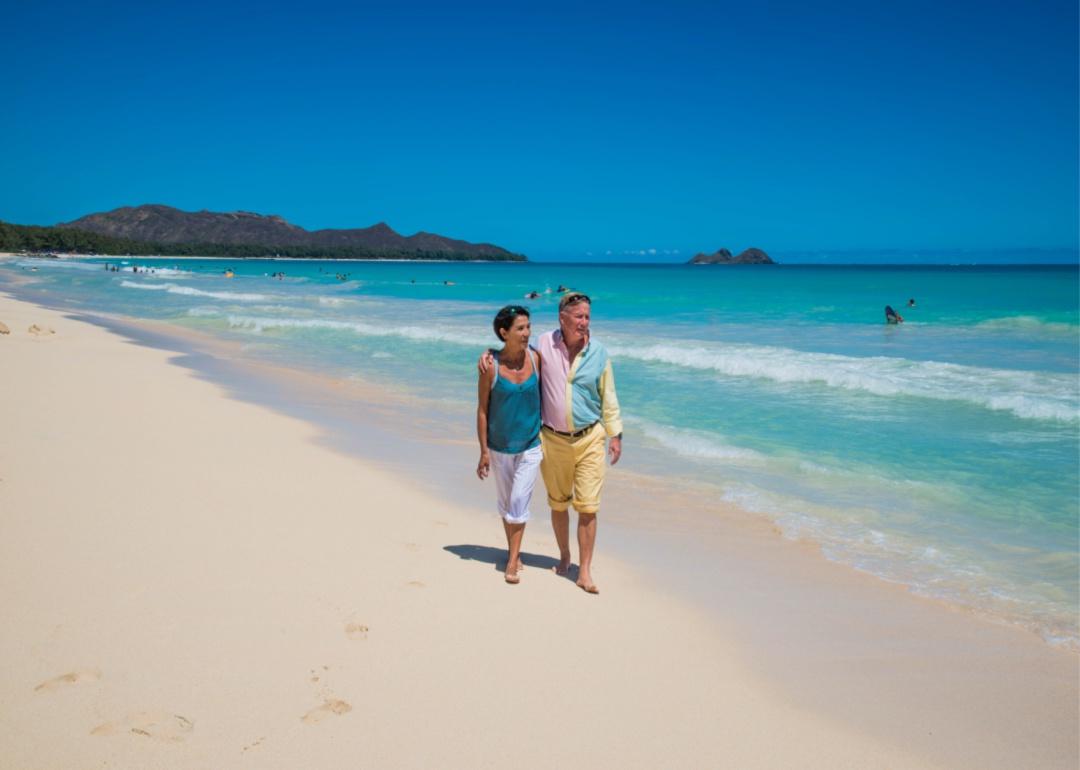 A couple walking on the beach in Honolulu.