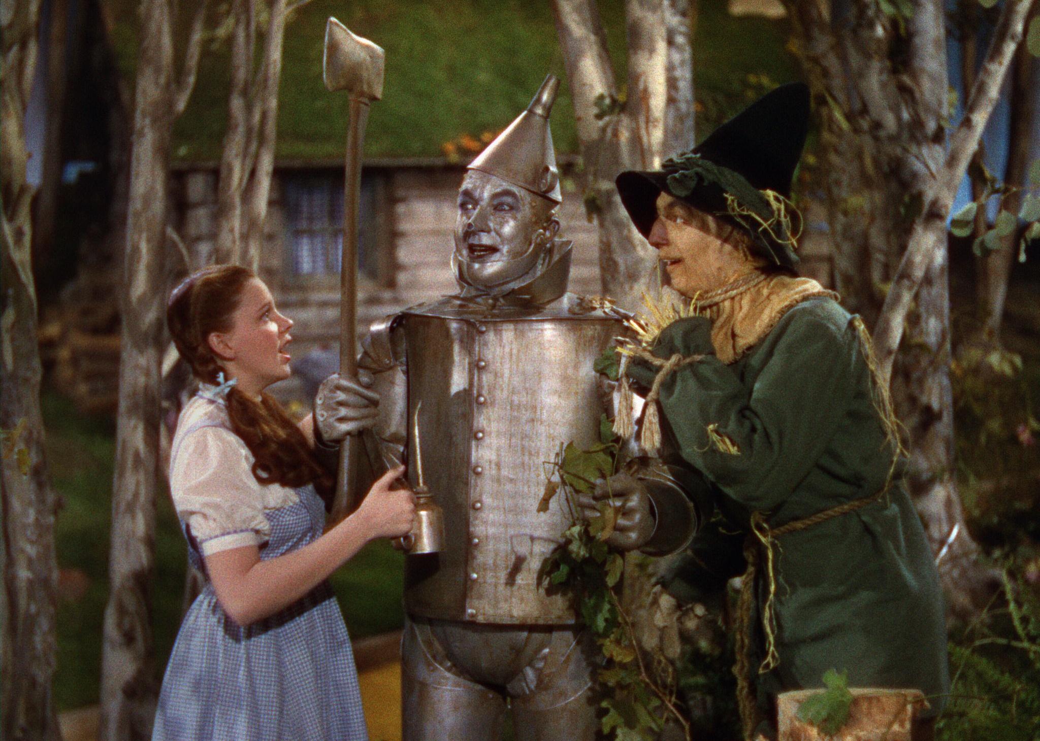 Judy Garland talking to a scarecrow and a tinman.