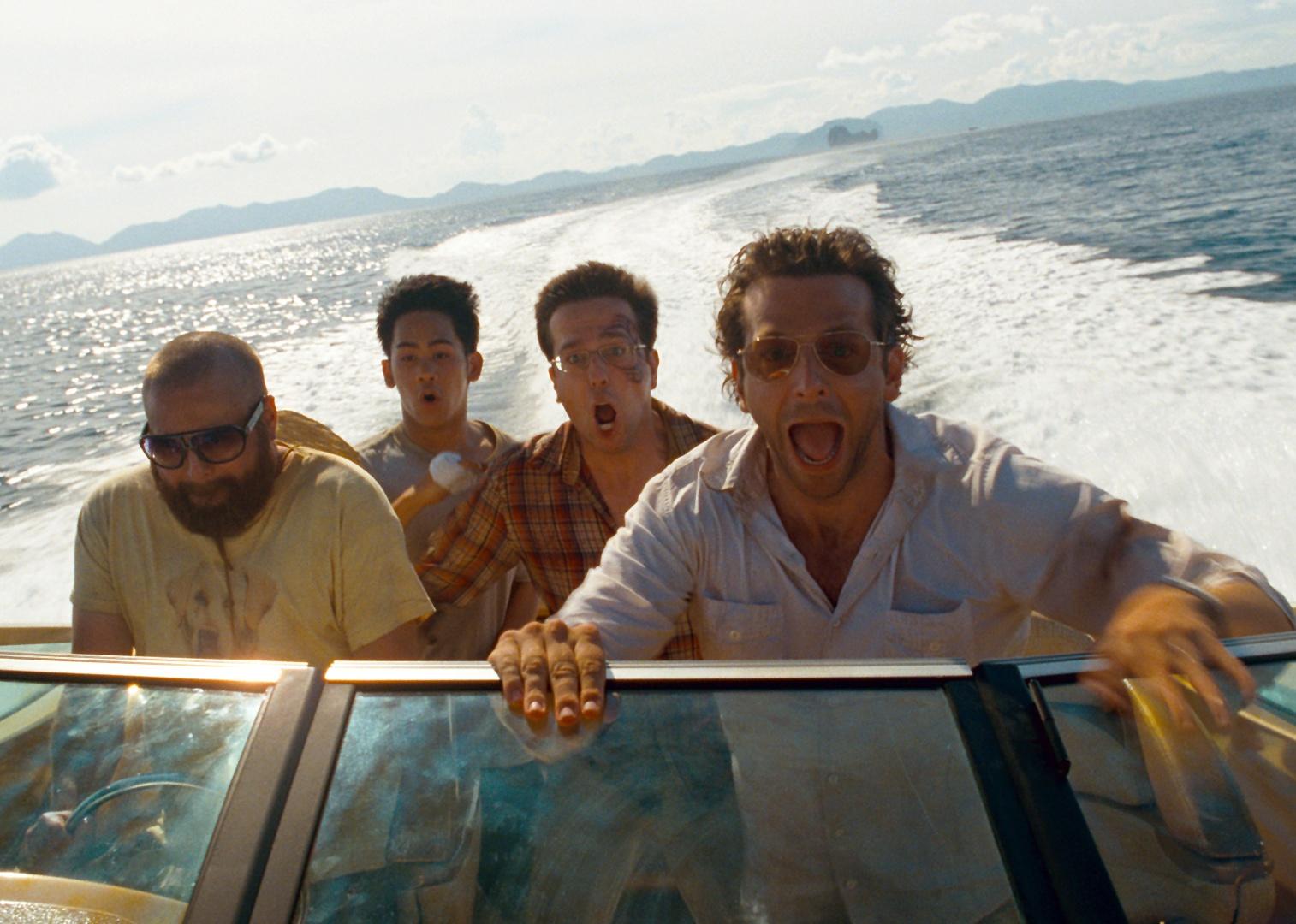 Bradley Cooper, Zach Galifianakis, Mason Lee, and Ed Helms with scared looks on their faces in a speed boat.