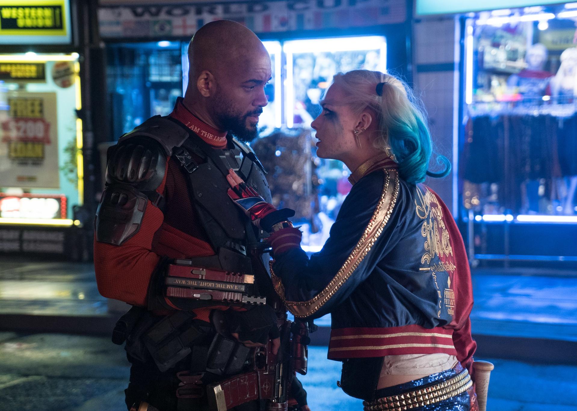 Will Smith and Margot Robbie talking in the street.