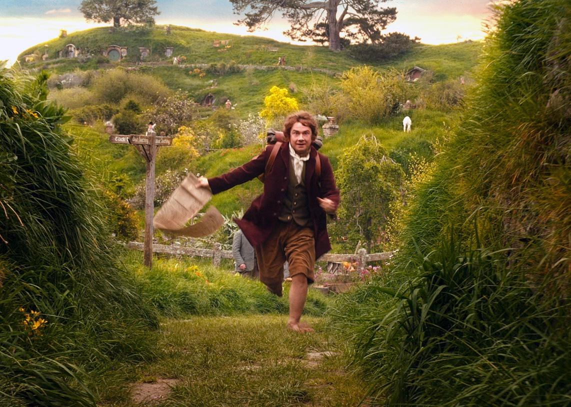 Martin Freeman running through a green valley.