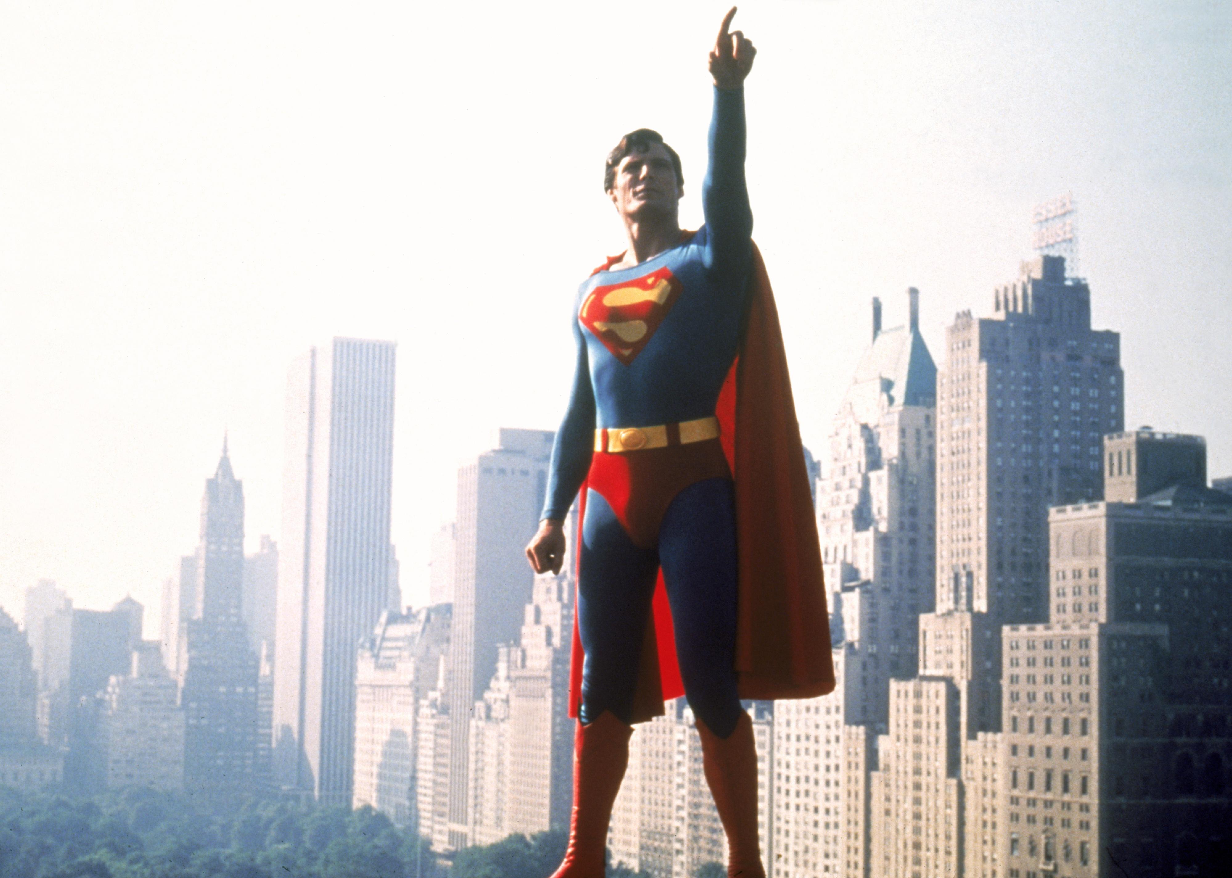 Christopher Reeve, as Superman, with a city skyline in the background.