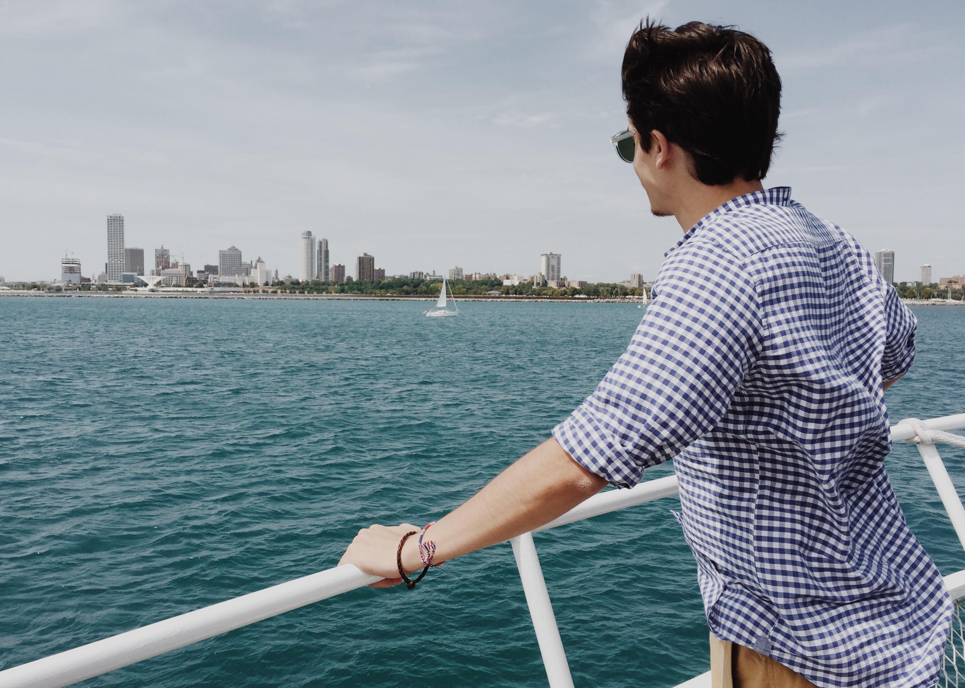 A man on a boat looks back to land.