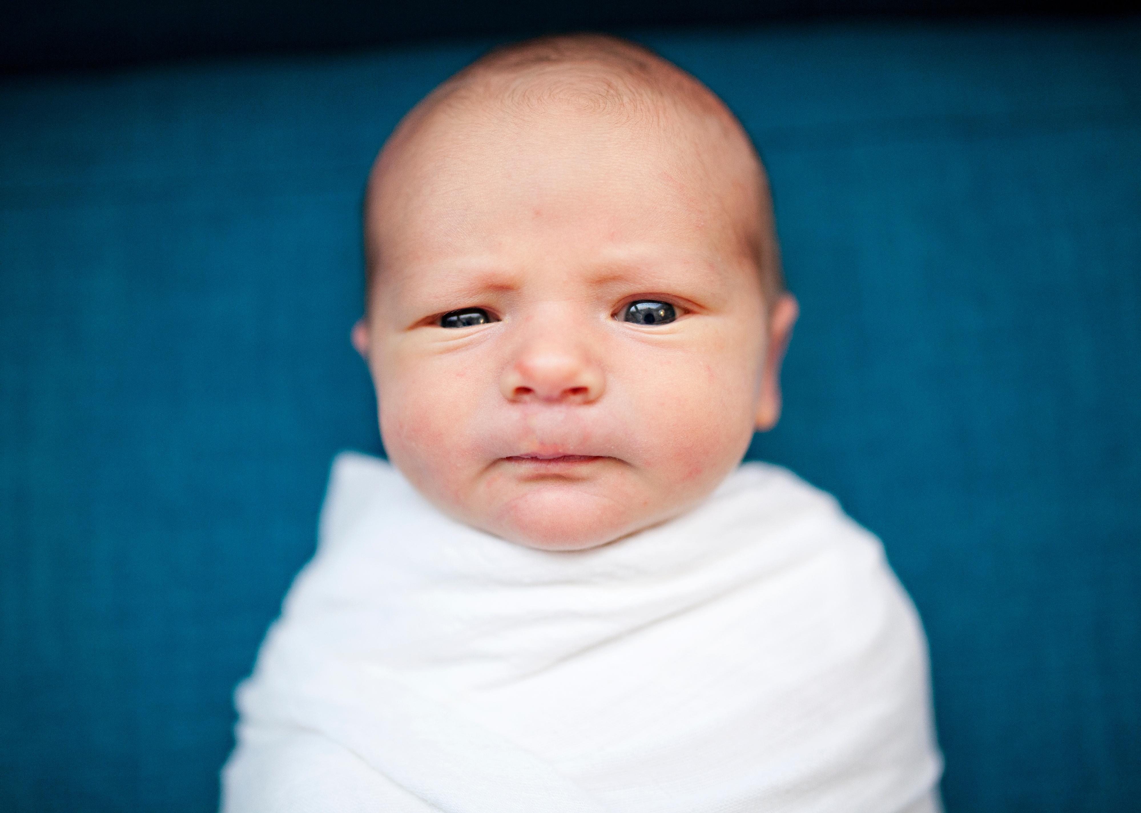 Baby wrapped in white blanket.