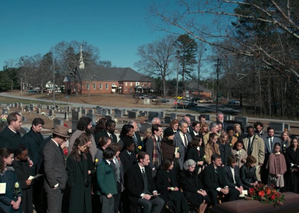 A large group attending an outdoor funeral.