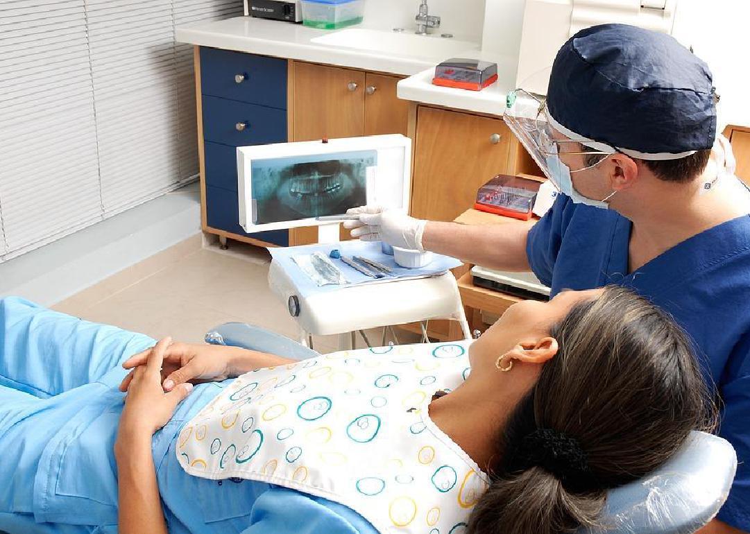 A dentist shows a patient their x-ray. 