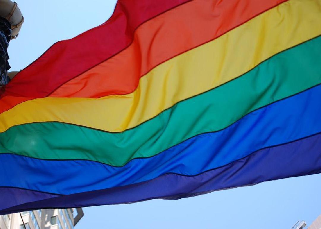 A rainbow flag blowing in the wind. 