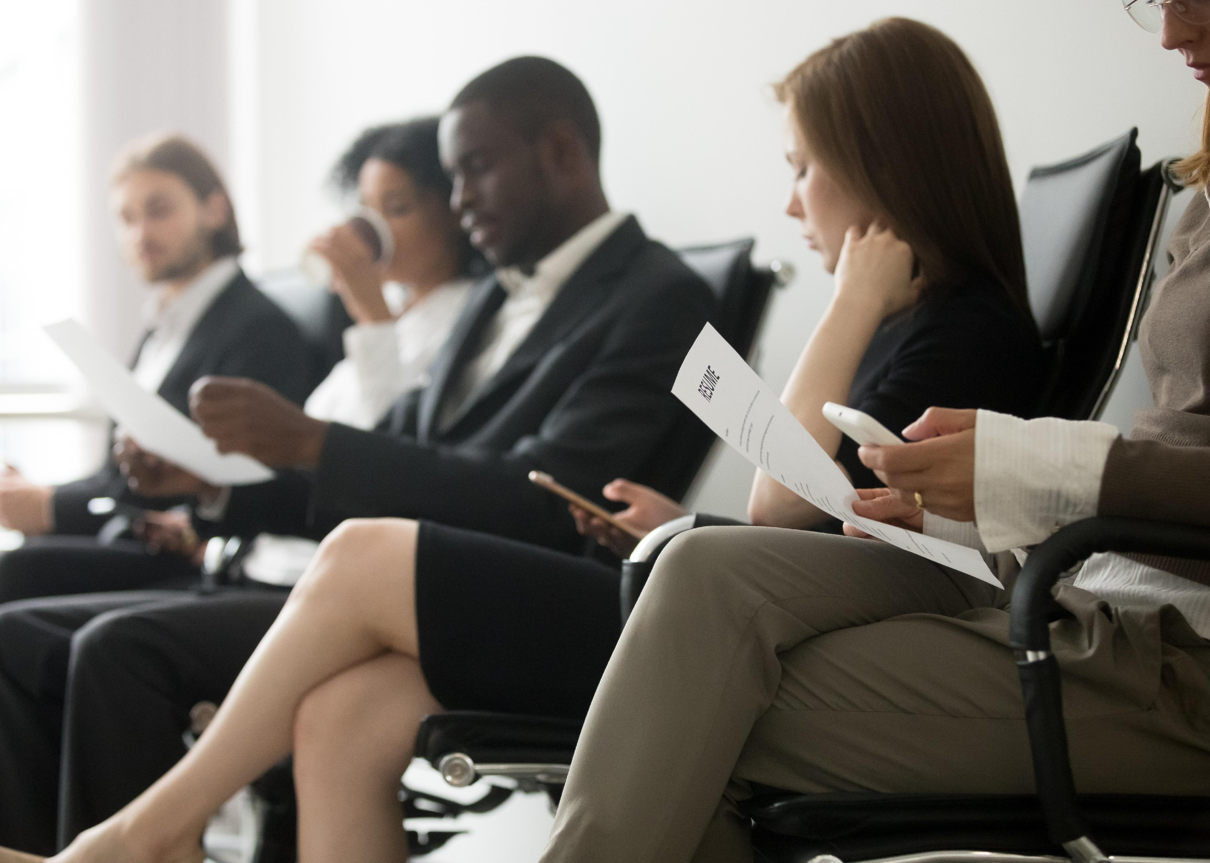 Applicants sitting in queue preparing for interview.