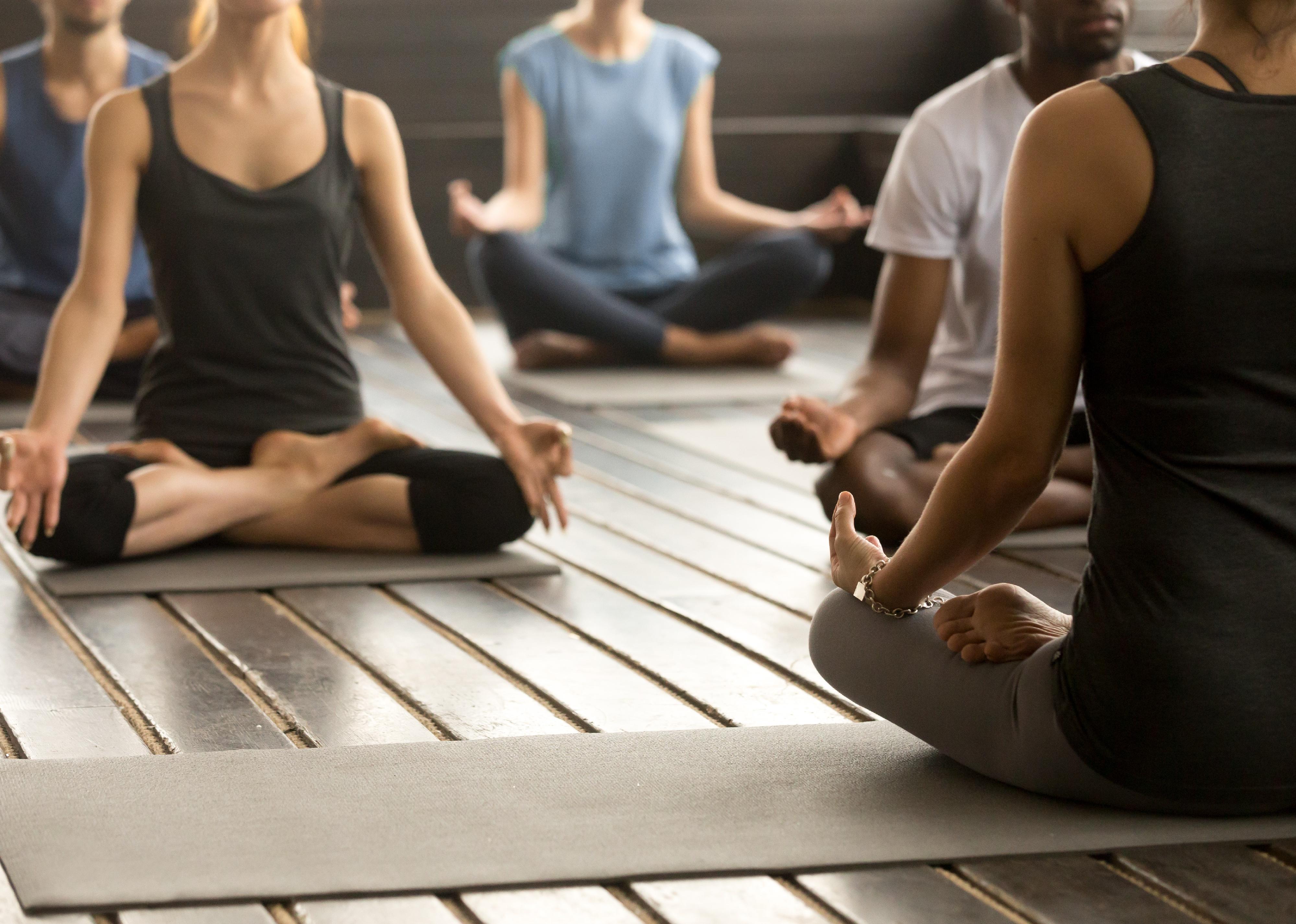 Group of people in a yoga class with instructor.