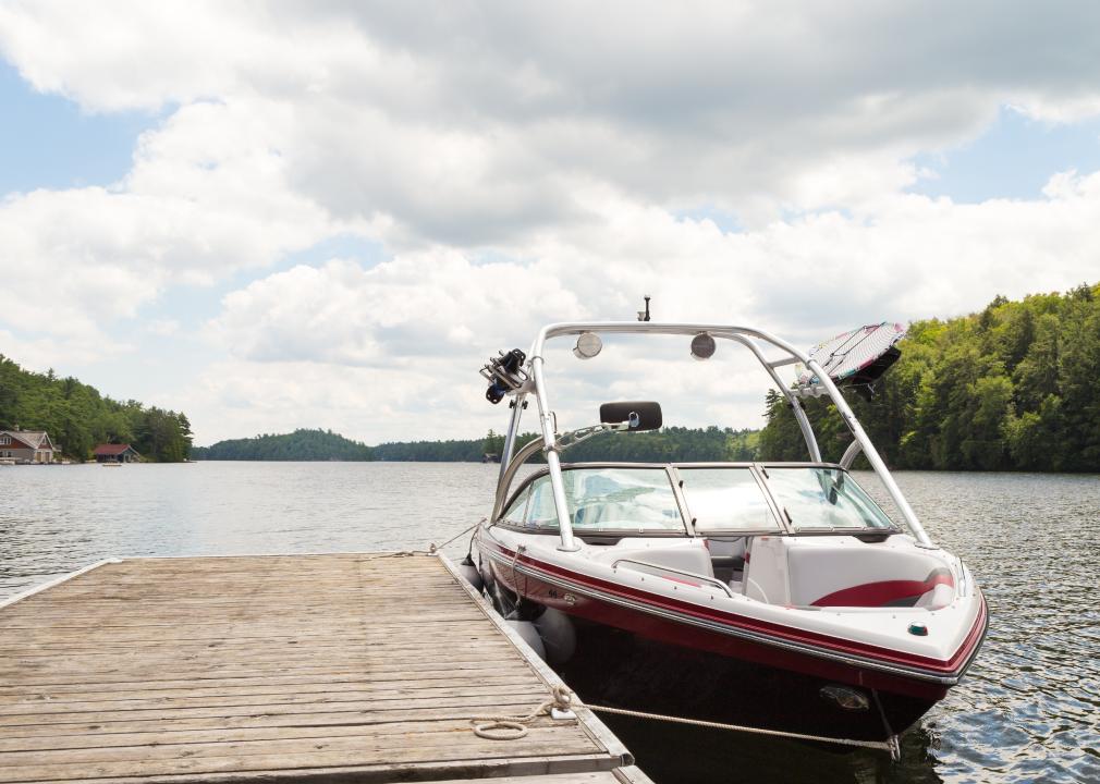 A wakeboard boat at a wooden dock in the Muskokas.