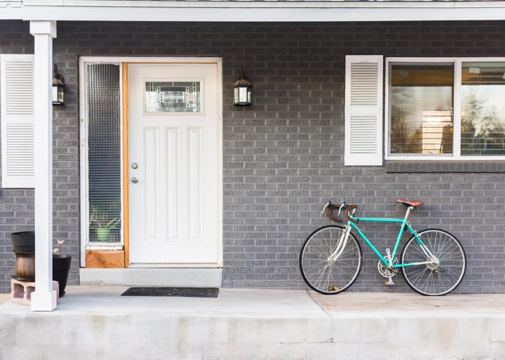 The front porch of a grey brick house.