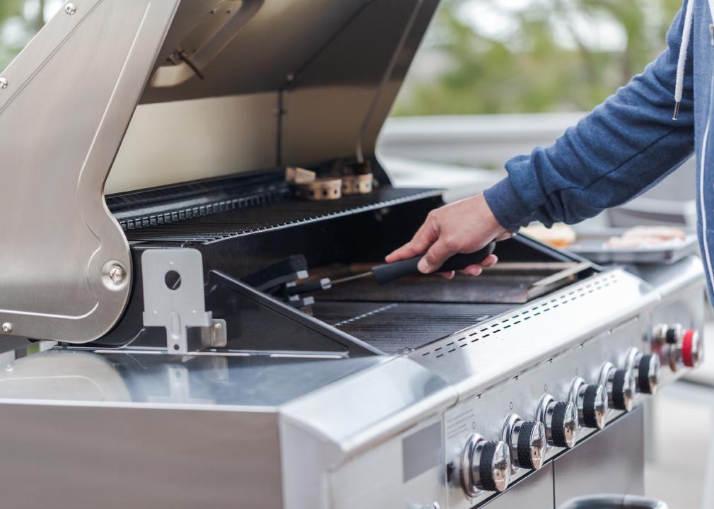 Man cleaning outdoor gas grill