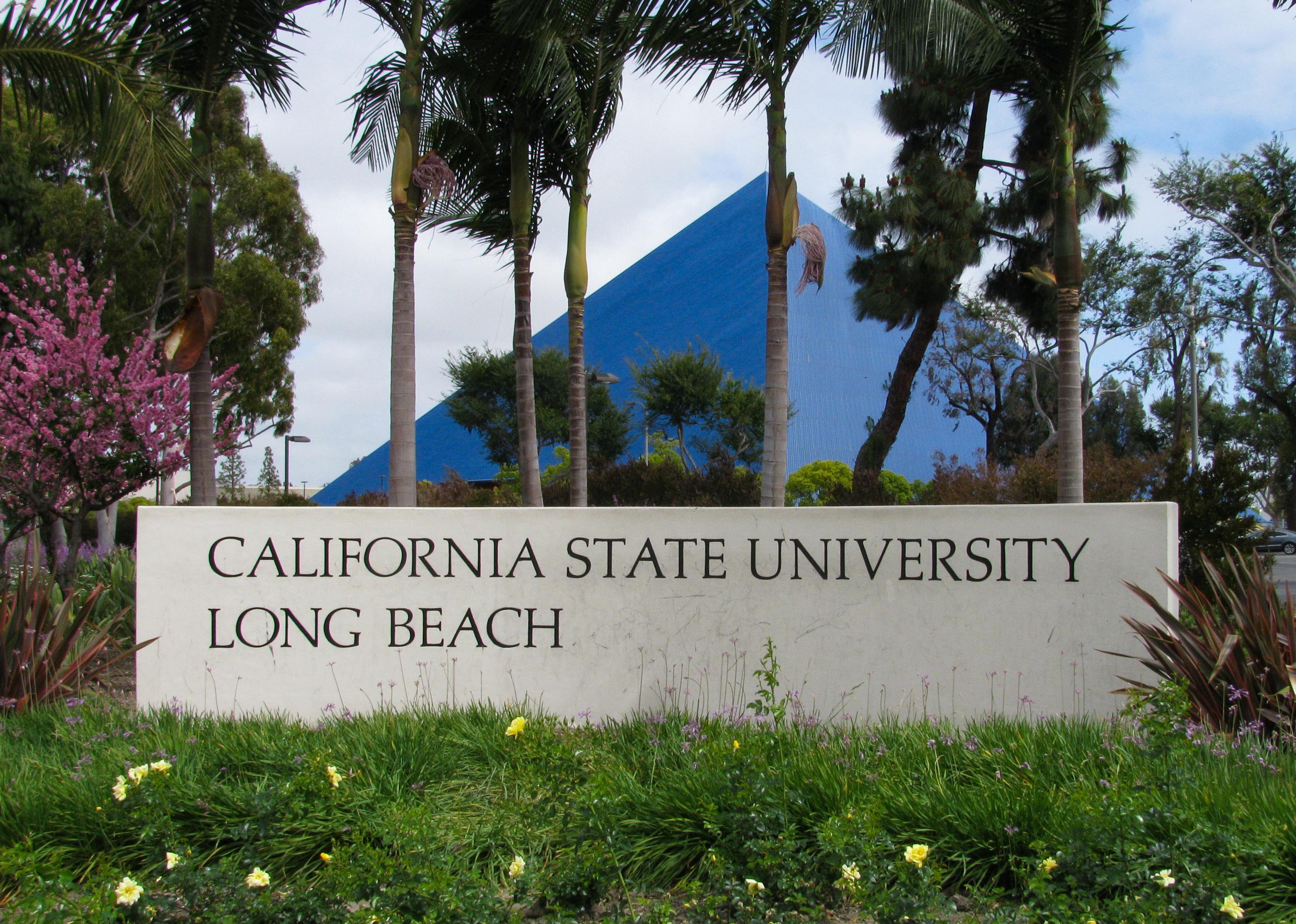 Entrance of California State University Long Beach with sign and a view of Walter Pyramid sports arena.