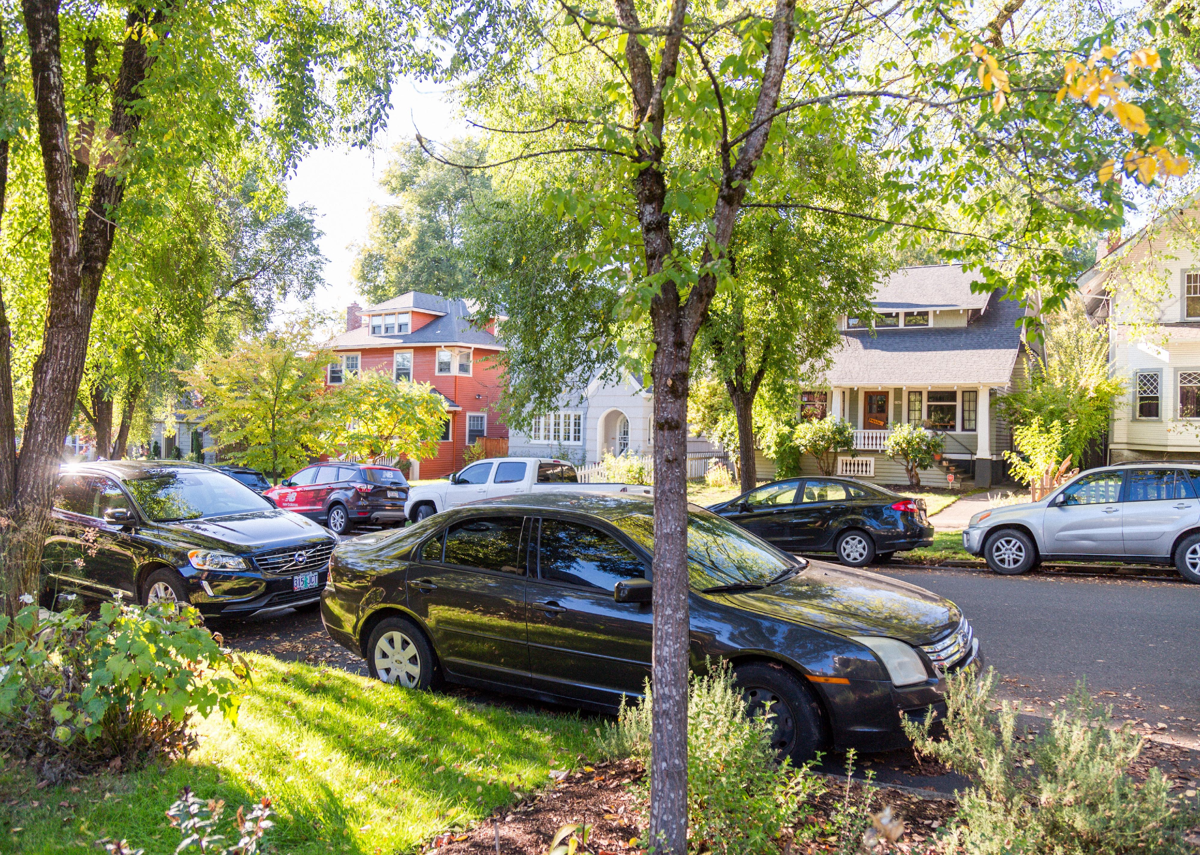 Residential neighborhood with parked cars and beautiful homes.