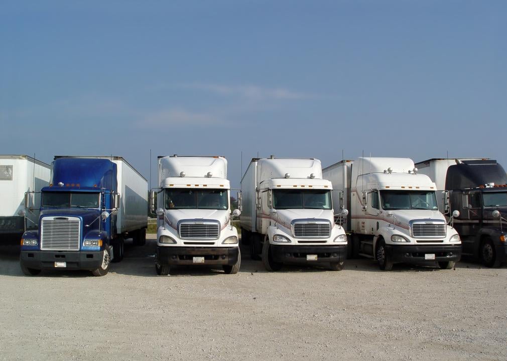 A row of trucks parked in a lot.