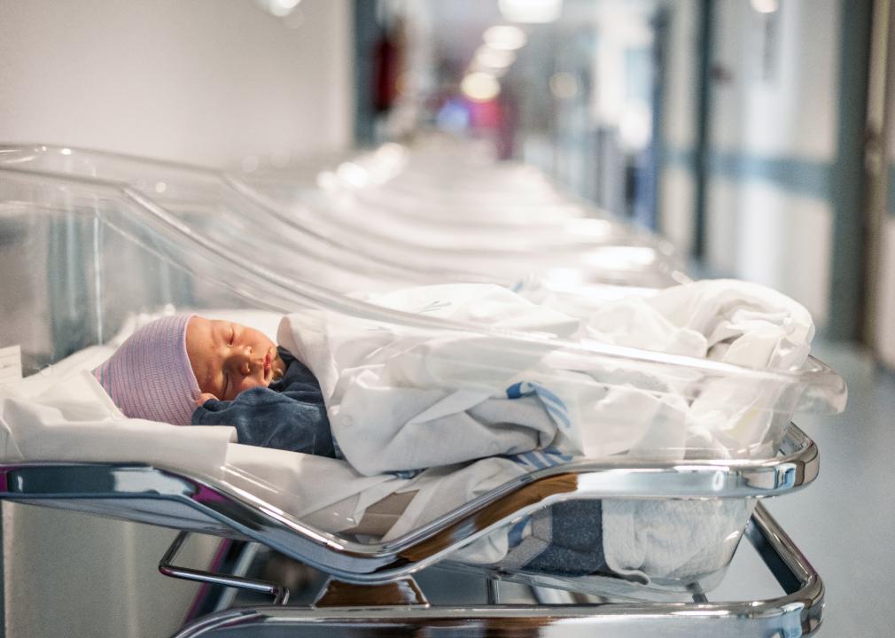 Newborn baby in a small hospital bed.