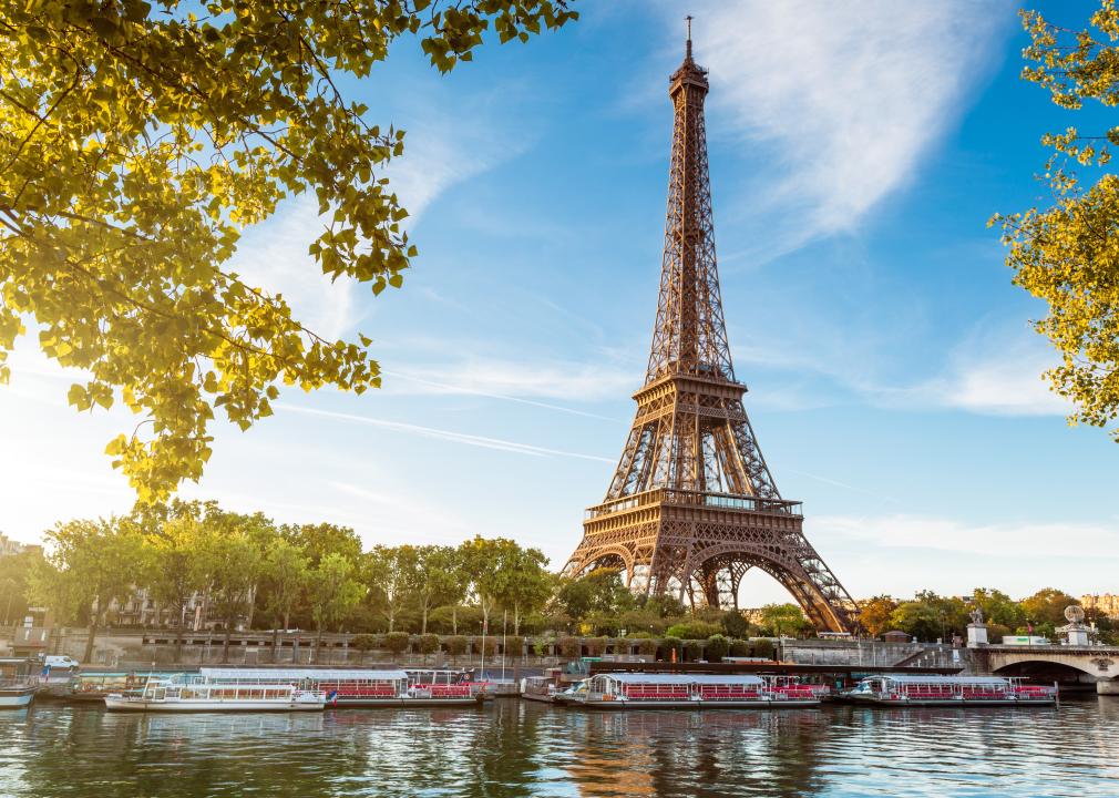 A view of the Eiffel tower in Paris framed by tree branches.