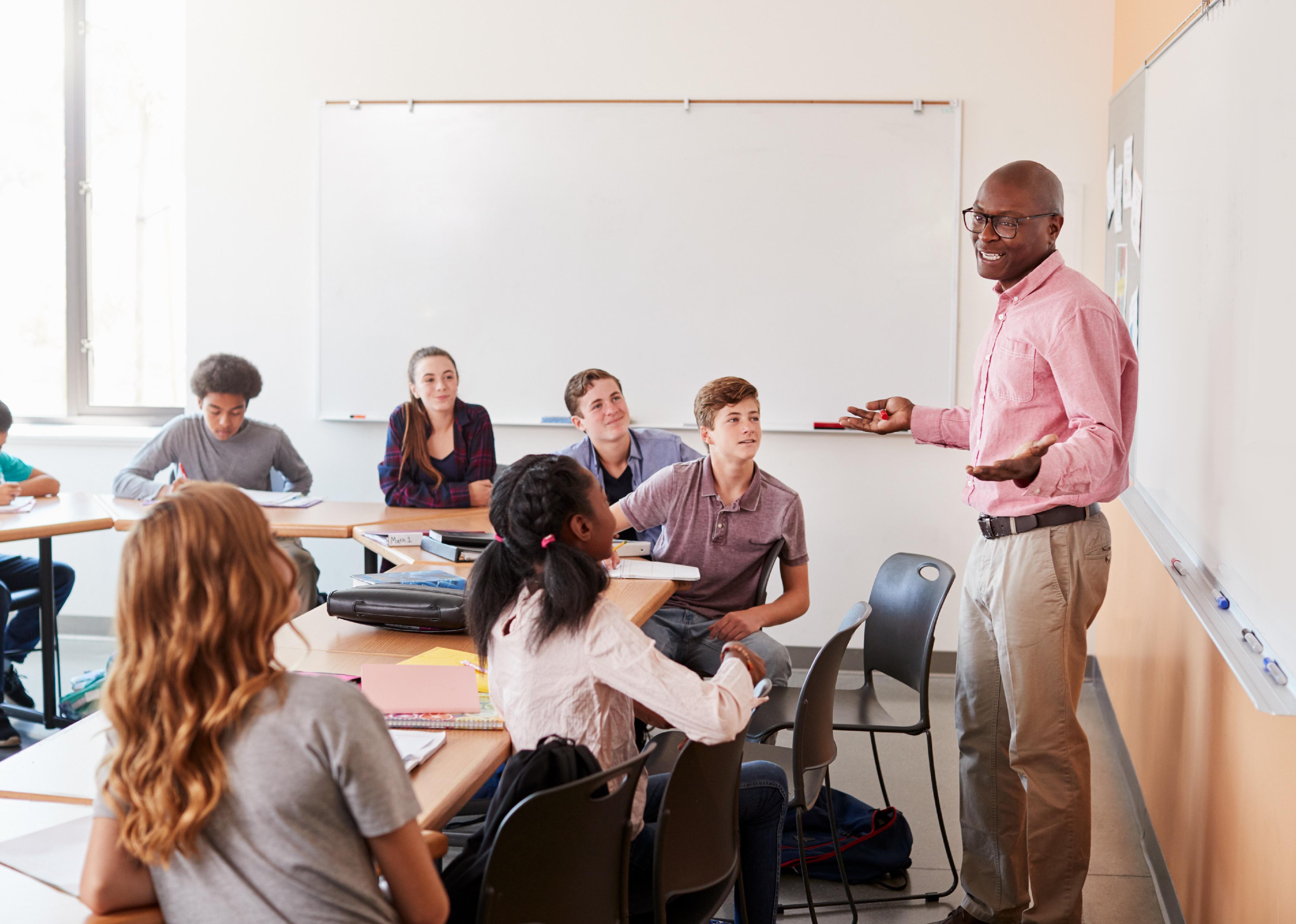 Male high school teacher standing at whiteboard