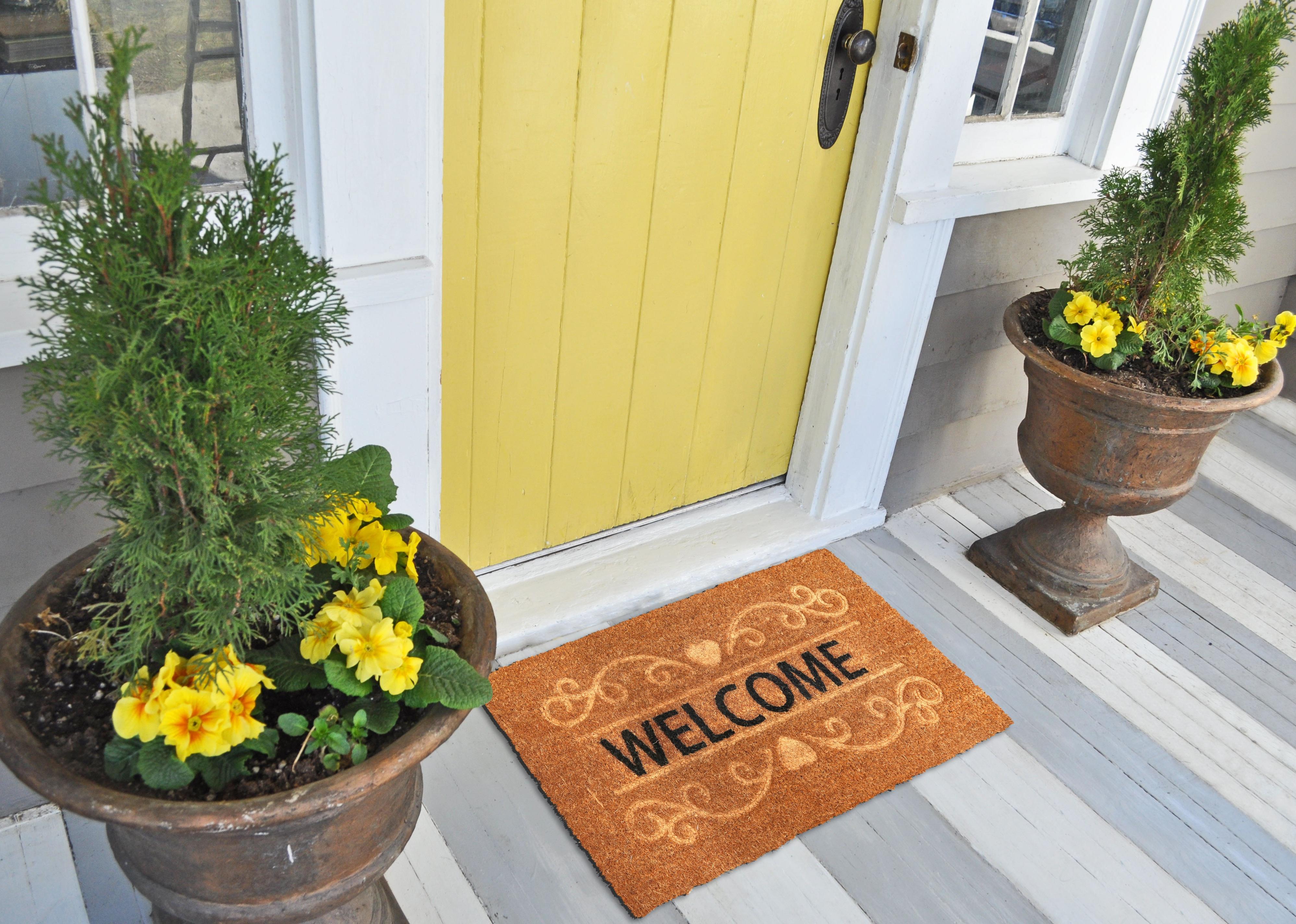 Welcome door mat outside of yellow front door.