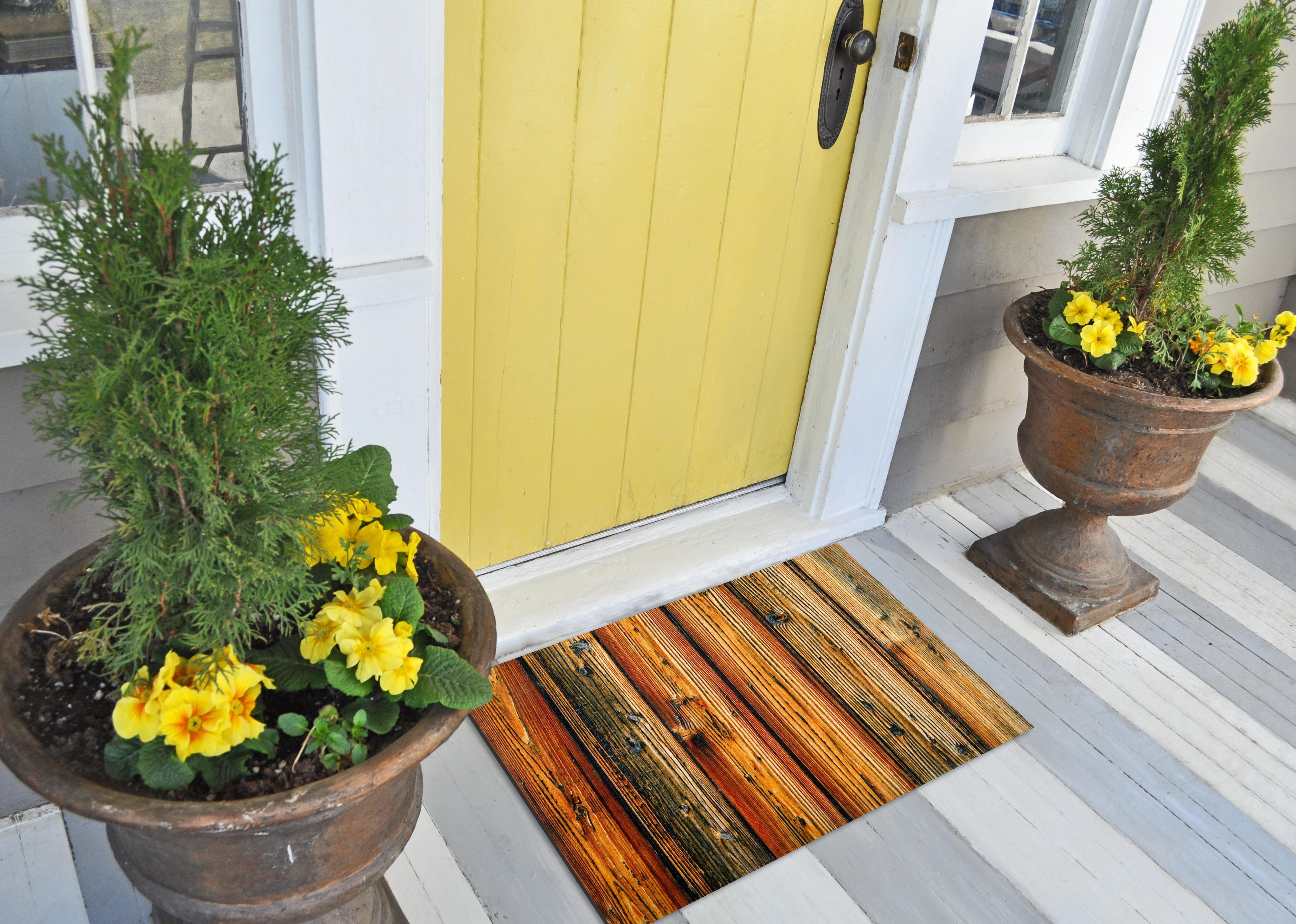 A yellow front door and a colorful doormat.
