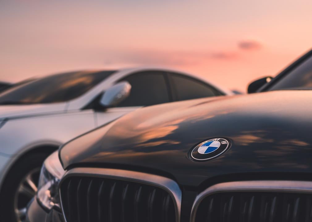 Close up of a BMW emblem on a car with sunset-filled sky.