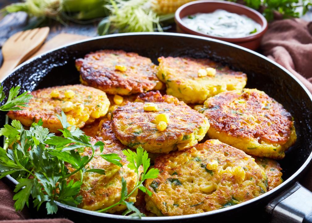 Fried corn fritters in a skillet.