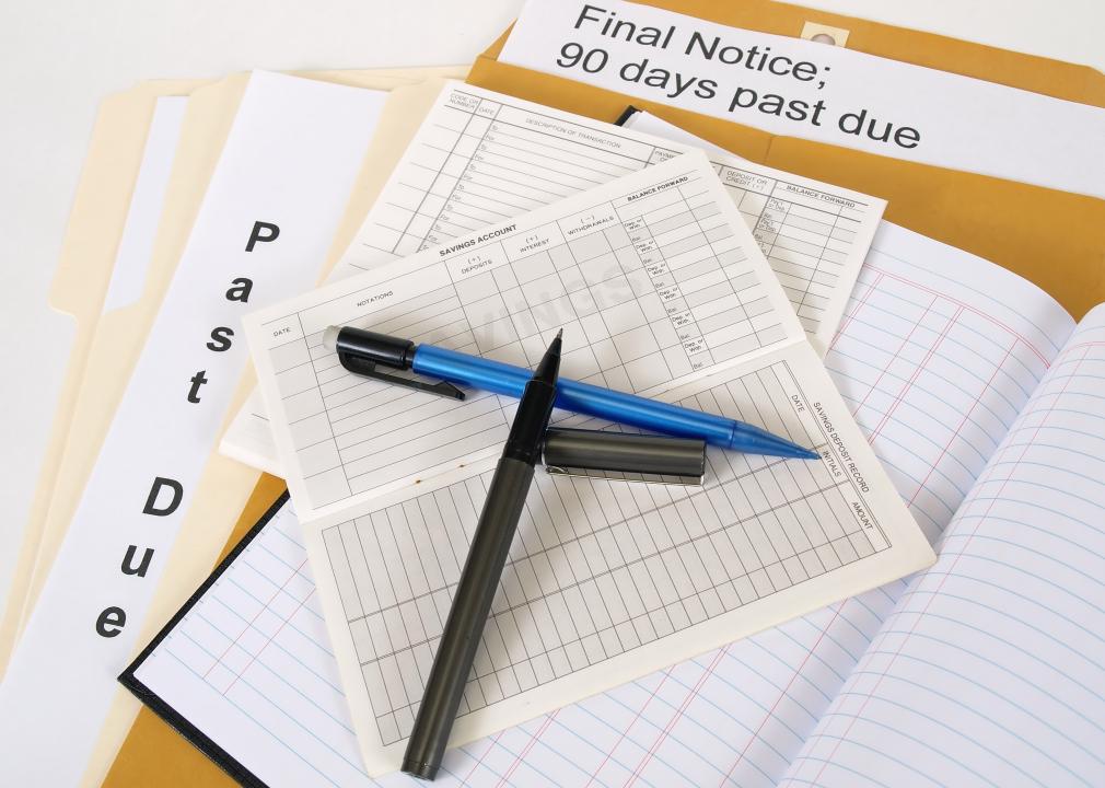 Balance sheets on top of a brown envelope showing a past due notice