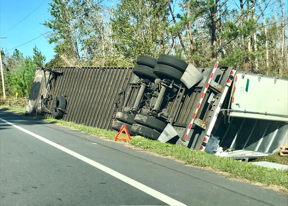 Semi truck on it's side on the side of the road