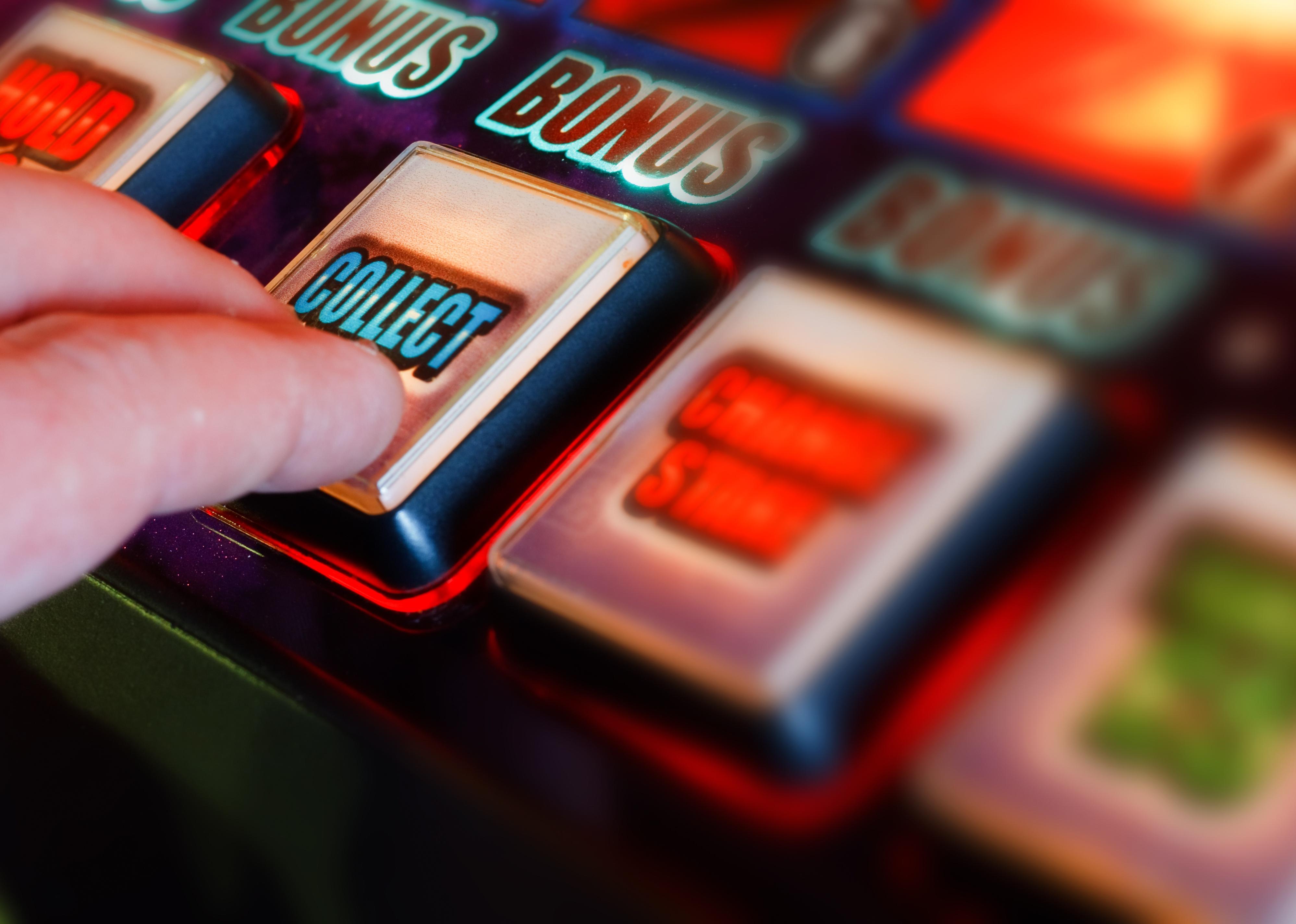 Fingers clicking "Collect" button on slot machine.