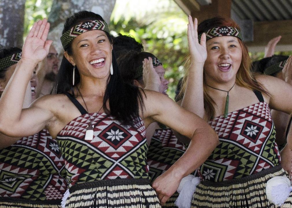 A small group of people dressed in traditional Maori clothing perform a dance.