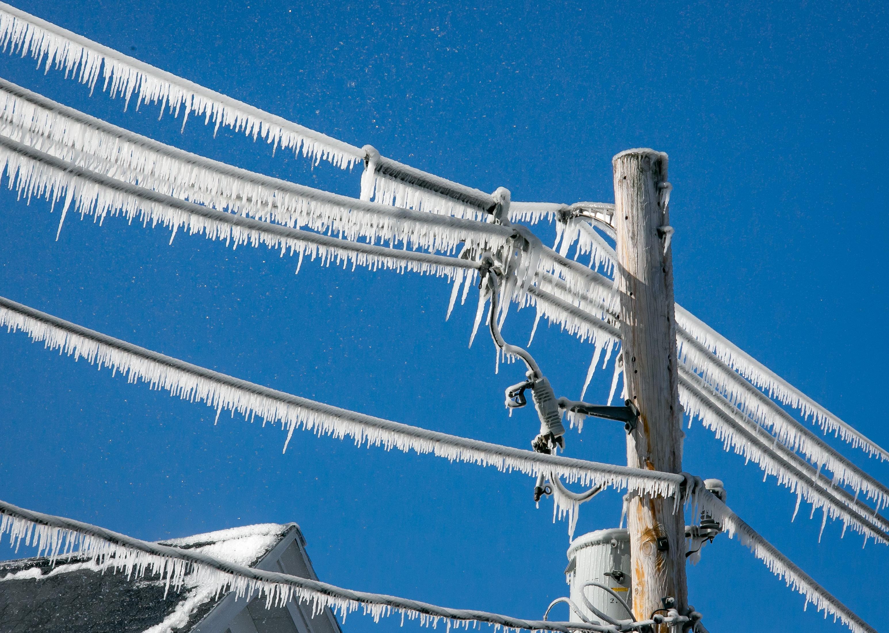 Utility pole and wires covered in ice.